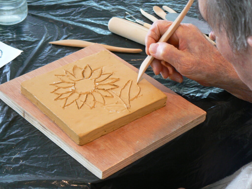 Atelier d'art-thérapie Dordogne - exemple de séance avec utilisation de la terre (argile) en gravure, personne agée